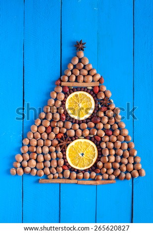Christmas tree made of spices, nuts and dried fruits on wooden background. Christmas concept background