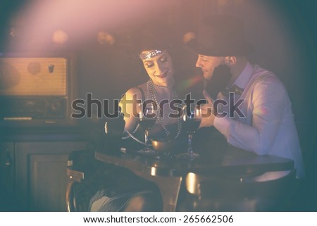 Retro couple.Couple with glasses of red wine in restaurant.Fashion,retro, vintage, tones. Antique picture with scratches and film grain.