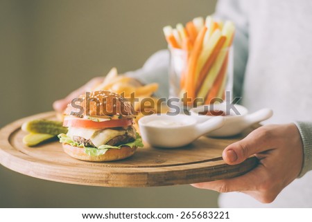 Lunch menu with small burger, french fries and vegetable sticks. Toned picture