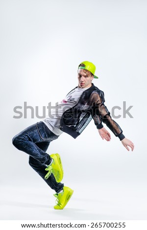 young beautiful modern style dancer posing on a studio background