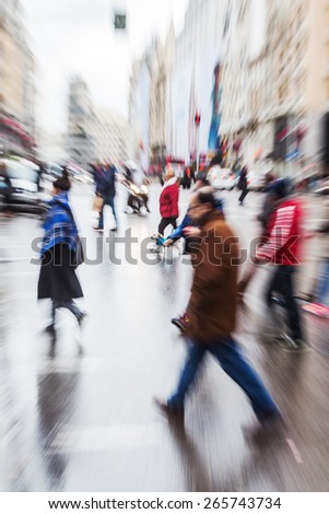 picture with zoom effect of people crossing a rainy street