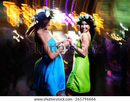 Portrait of the happy girlfriends dancing in a disco. 