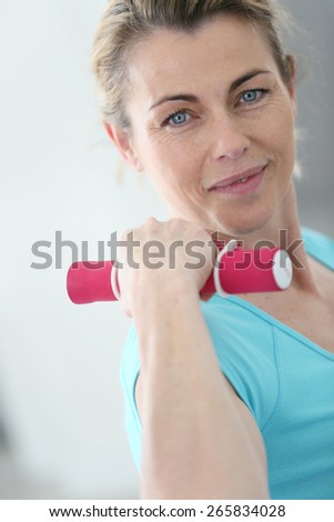 Portrait of mature fitness woman lifting dumbbells