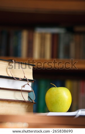 glasses on the books and green apple