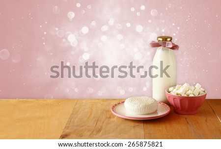 image of greek cheese , bulgarian cheese and milk on wooden table over vintage rustic  background. Symbols of jewish holiday - Shavuot
