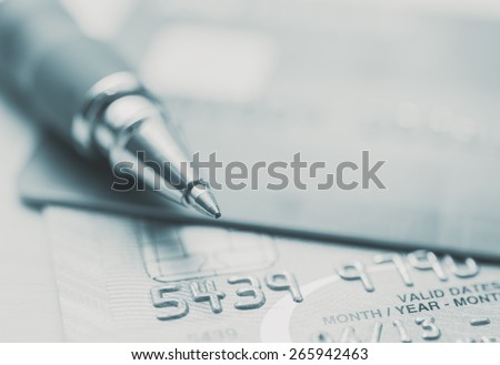 Split toned image of credit cards and a pen Royalty-Free Stock Photo #265942463