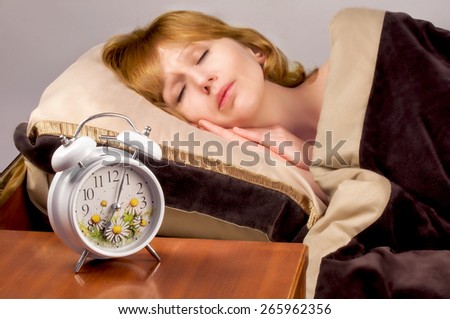 alarm clock and sleeping girl on the background
