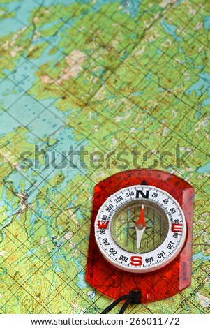 The compass on the map. Photo magnetic compass located on a topographic map.