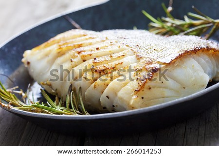 Fried fish fillet, Atlantic cod with rosemary in pan Royalty-Free Stock Photo #266014253