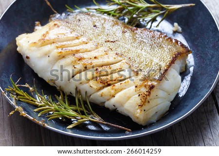 Fried fish fillet, Atlantic cod with rosemary in pan Royalty-Free Stock Photo #266014259