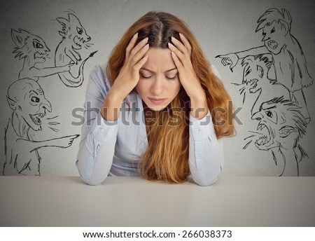 Evil Men pointing at stressed woman. Desperate young businesswoman sitting at desk in her office isolated on grey wall background. Negative human emotions face expression feelings life perception Royalty-Free Stock Photo #266038373