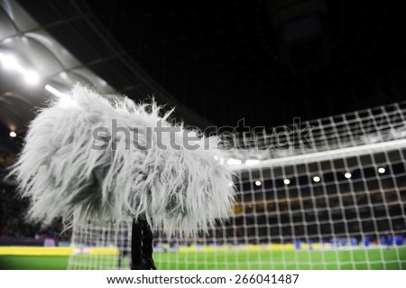 Furry sport microphone on a soccer field with sport arena in background