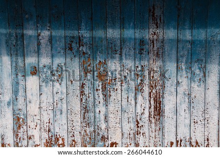 Old peeling blue paint on weathered wood as a detailed grunge background image.