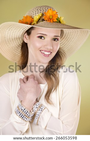 woman wearing hat with flowers on light green background