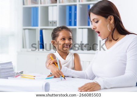 Shocked business woman looking at the pictures her daughter drew on the business documents
