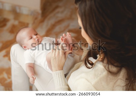 Portrait of a mother with her 4 months old baby at home. Happy child near to mum in her room. Portrait of a mother with her newborn baby. 