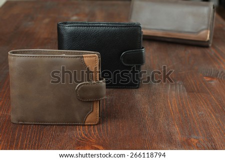 three male purse on wood background