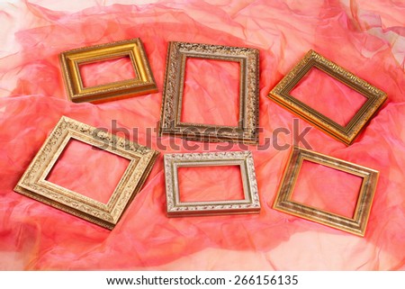 collection of vintage gold frames on red silk