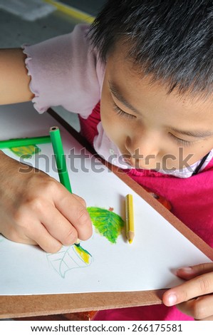closeup little asian girl hand draw her  picture with color pencil. Education Concept.