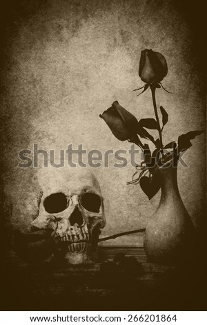 still life with skull on wooden table over grunge background