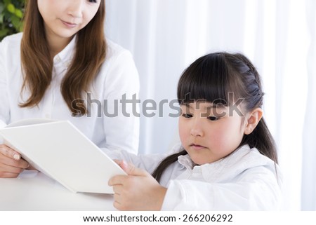 mother and daughter is reading a book