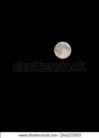 Fully illuminated Moon isolated on black sky 