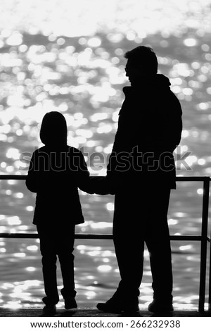 daddy and his daughter in a back light