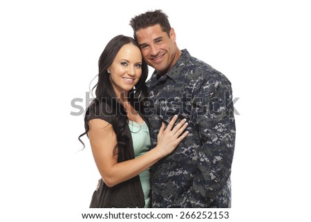 Happy navy man embracing his wife against white background