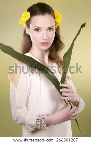 cuacasian woman wearing yellow flowers on green background