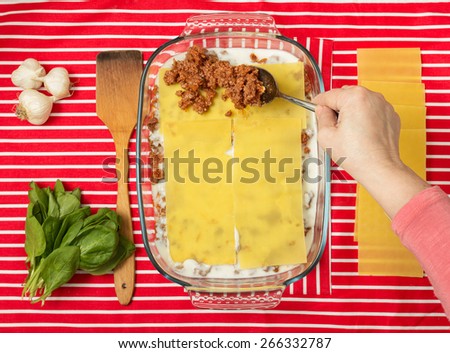 Making of tasty Italian lasagna on a bright background