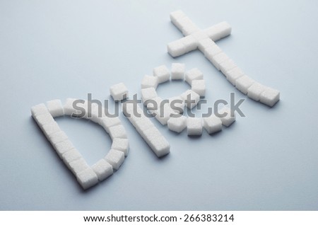 Concept: Diet text made of sugar cubes over blue background, above view