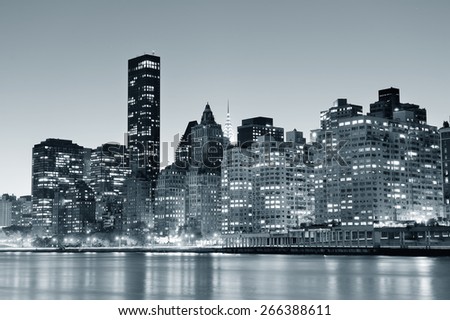 New York City Manhattan midtown skyline black and white at night over East River.