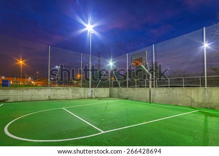 Basketball court illuminated at dusk