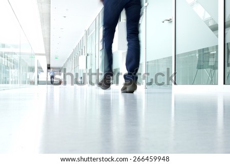 business people walking in the office corridor of an business center, pronounced motion blur Business people walking in the office corridor