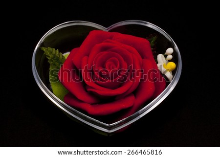 Red rose inclosed in heart shape casing with black background