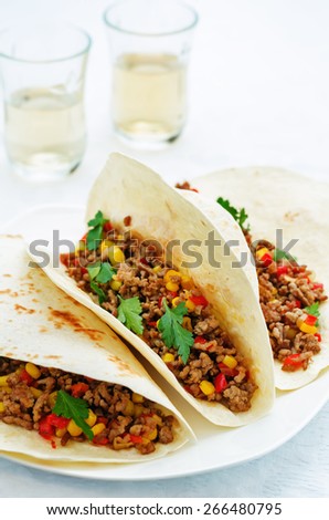tacos with meat, corn and peppers on a white background. tinting. selective focus