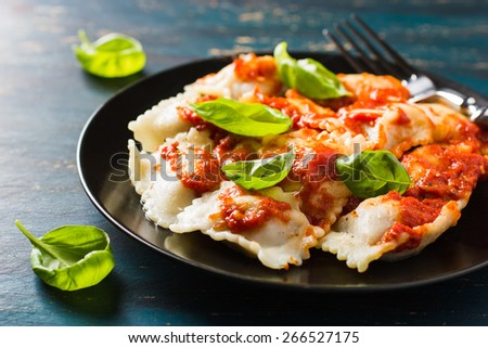 Ravioli with tomato sauce and basil on dark background Royalty-Free Stock Photo #266527175