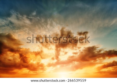 Cumulus sunset clouds with sun setting down