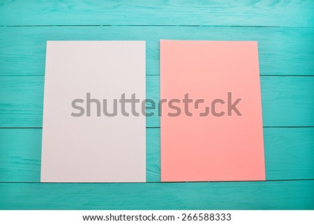 Two peace of papers on blue wooden background