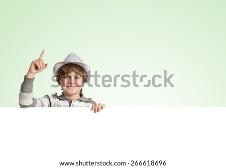 Cute boy of school age with blank advertising board