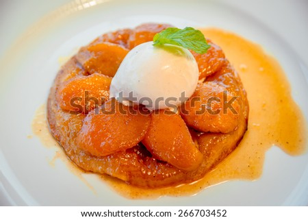 Fruit dessert with a scoop of ice cream on a white plate. The Restaurant