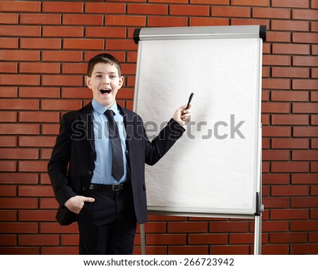 Boy standing near white office board.