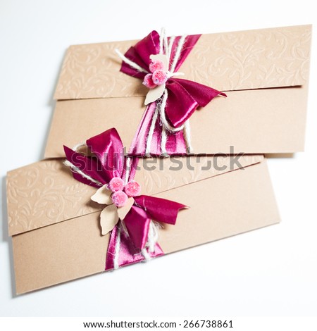 Close up on two envelopes with ribbon bow on light background