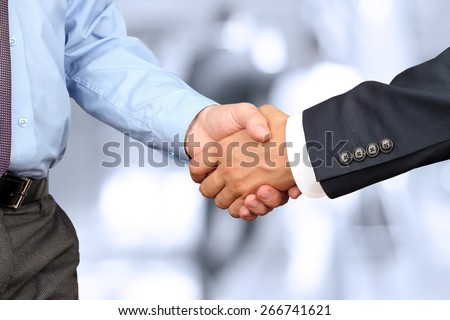  The Close-up image of a firm handshake between two colleagues in office.