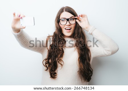 brunette girl photographed themselves on the phone on a white background