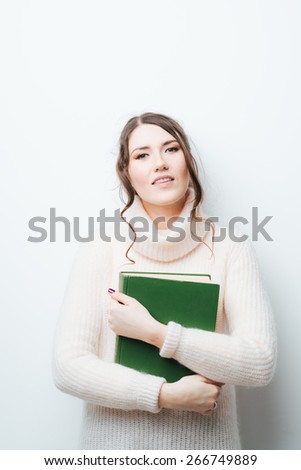 brunette girl with big book in hand in hand on a white background