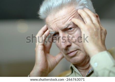 Portrait of an elderly man with headache