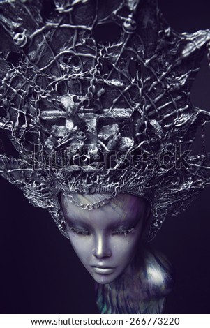 Female Mannequin in metallic head wear with chains on dark background