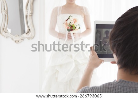 Husband taking picture of his wife on wedding.