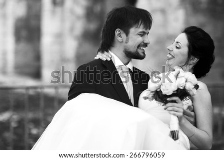 cute rich happy groom holds a bride smiling sunny Rome smiling and look at each other black and white